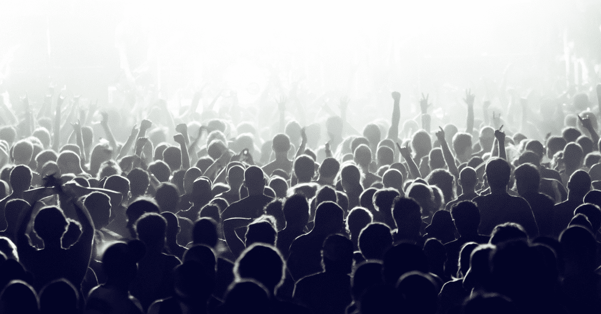 Black and white photo of a crowd with those closest to the front in a bright white light