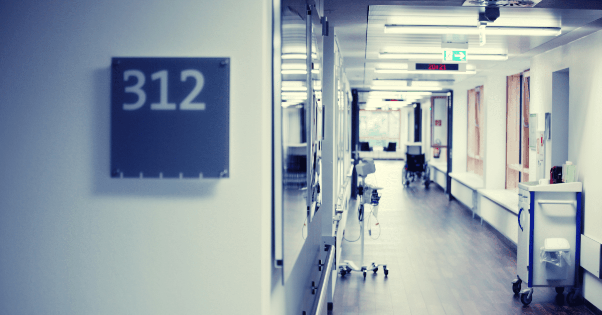 Photograph of a hospital hallway with the room number 312 showing.