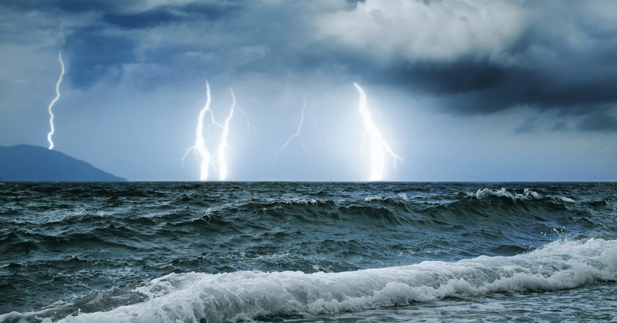 photograph of choppy seas with multiple bolts of lightening