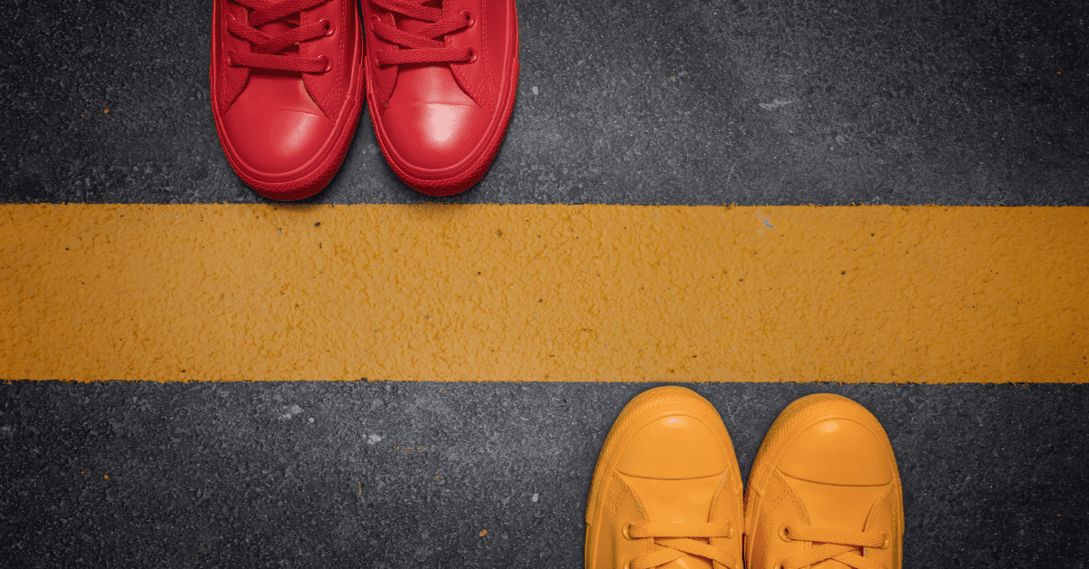 two sets of shoes facing each other on a road marking stripe
