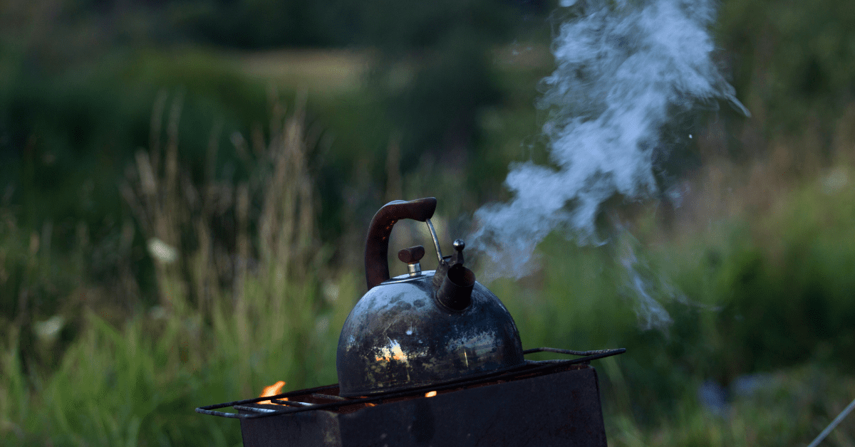 A boiling kettle on a campfire