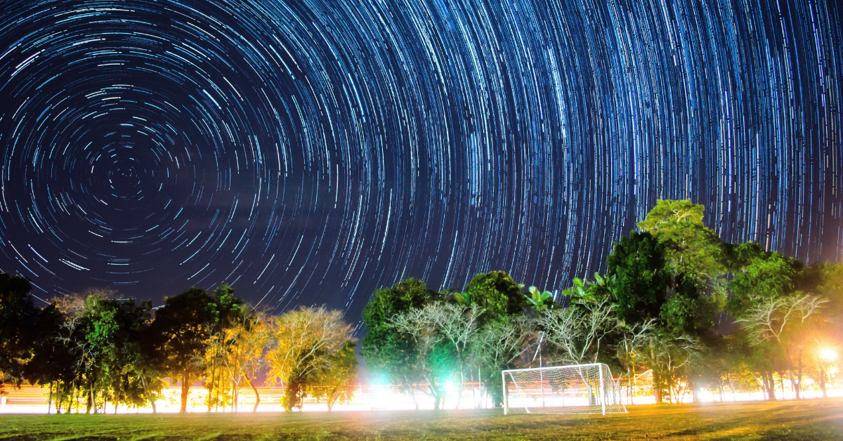 blurred stars over a soccer pitch at night